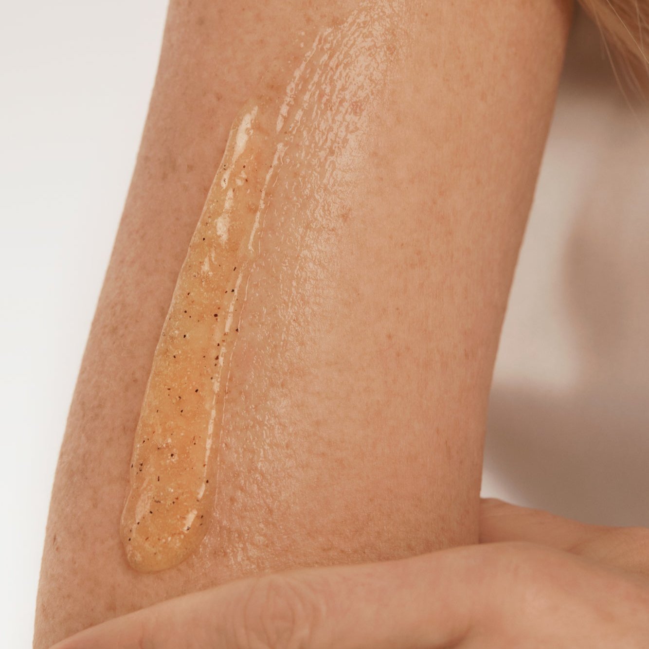 Application d’un gel exfoliant corporel NU•RISH sur la peau, texture naturelle avec grains exfoliants pour lisser et revitaliser l’épiderme. Application of NU•RISH body exfoliating gel to the skin, natural texture with exfoliating grains to smooth and revitalize the epidermis.