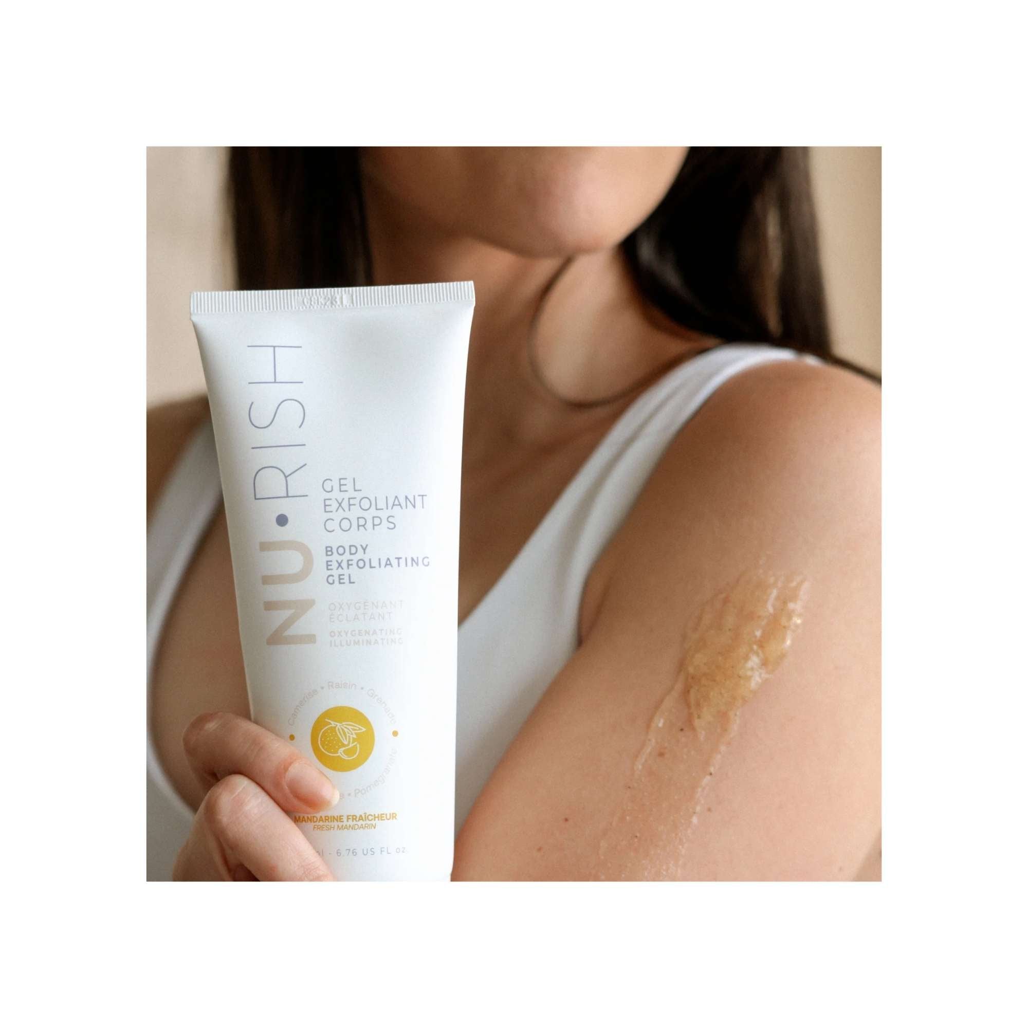 Femme qui tient dans sa main le gel exfoliant pour le corps de chez NURISH. Woman holding NURISH body exfoliating gel in her hand.