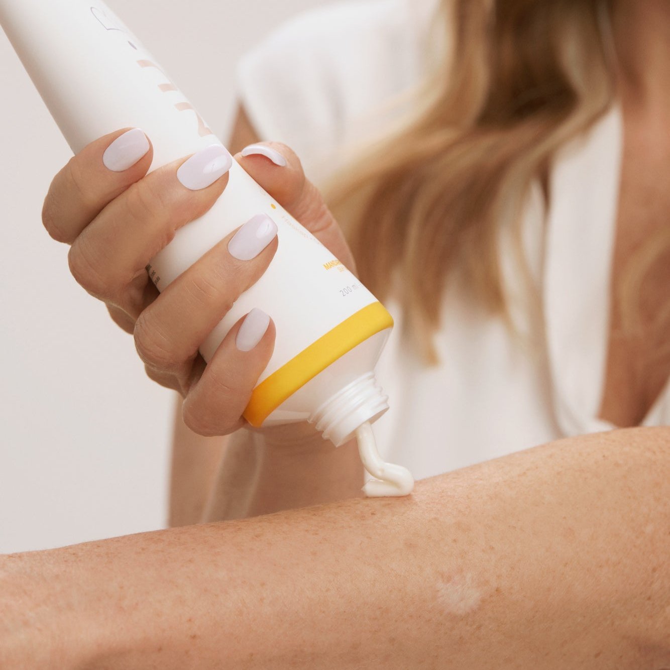 Application du lait pour le corps NU•RISH sur l’avant-bras, texture crémeuse appliquée à la main pour hydrater et nourrir la peau. Application of NU•RISH body milk to the forearm, creamy texture applied by hand to moisturize and nourish the skin.